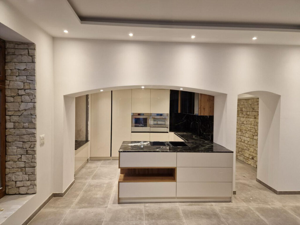 Moderne Küche nach Mass mit Naturstein, Insel und architektonischem Design in der Schweiz