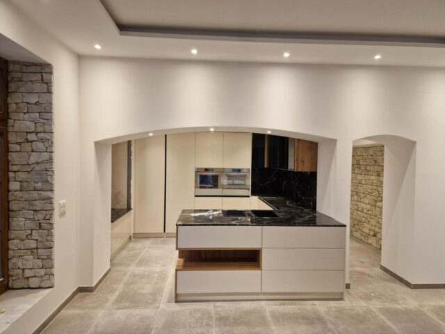 Moderne Küche nach Mass mit Naturstein, Insel und architektonischem Design in der Schweiz