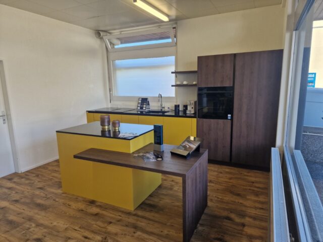 Moderne Küche nach Mass mit gelber Kochinsel und Holzelementen