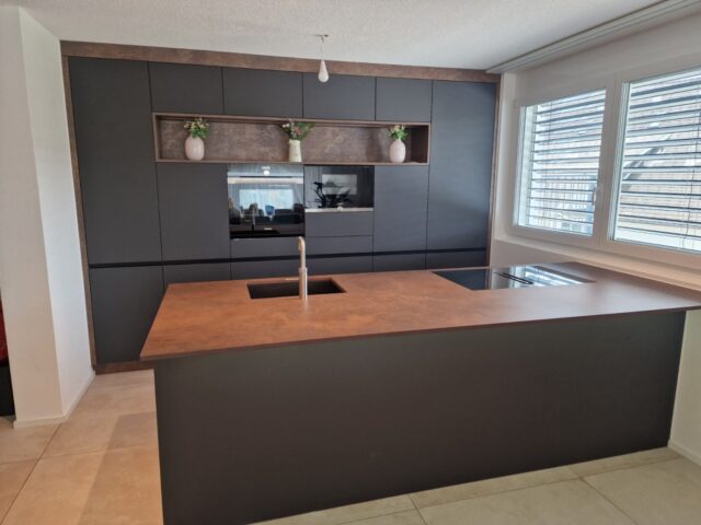 Moderne dunkle Küche nach Mass mit Kochinsel und Arbeitsplatte in Holzoptik