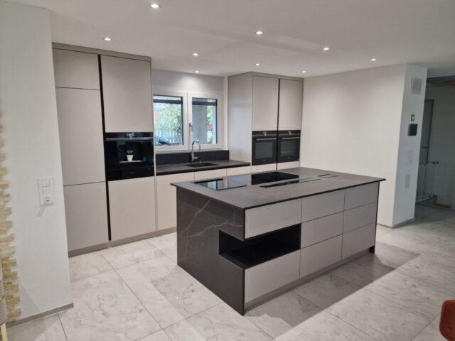 Moderne helle Küche nach Mass mit Kochinsel und klaren Linien