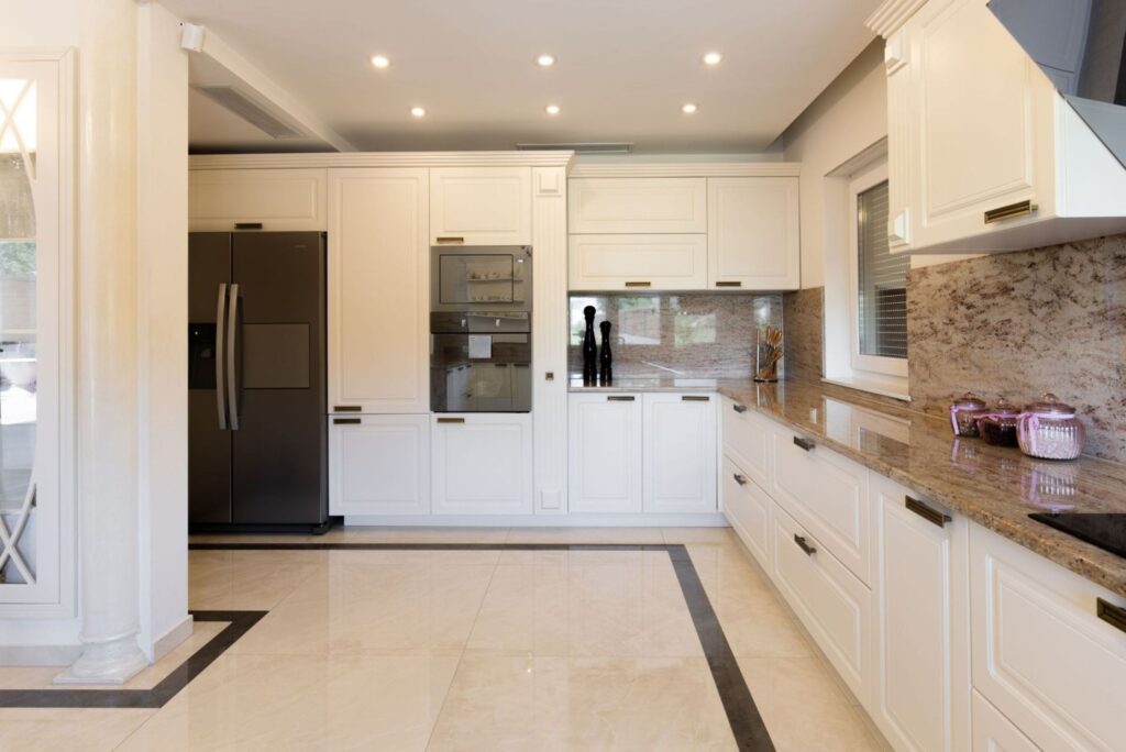 Klassische Küche nach Mass mit weissen Fronten und Naturstein Arbeitsplatte – Schweiz