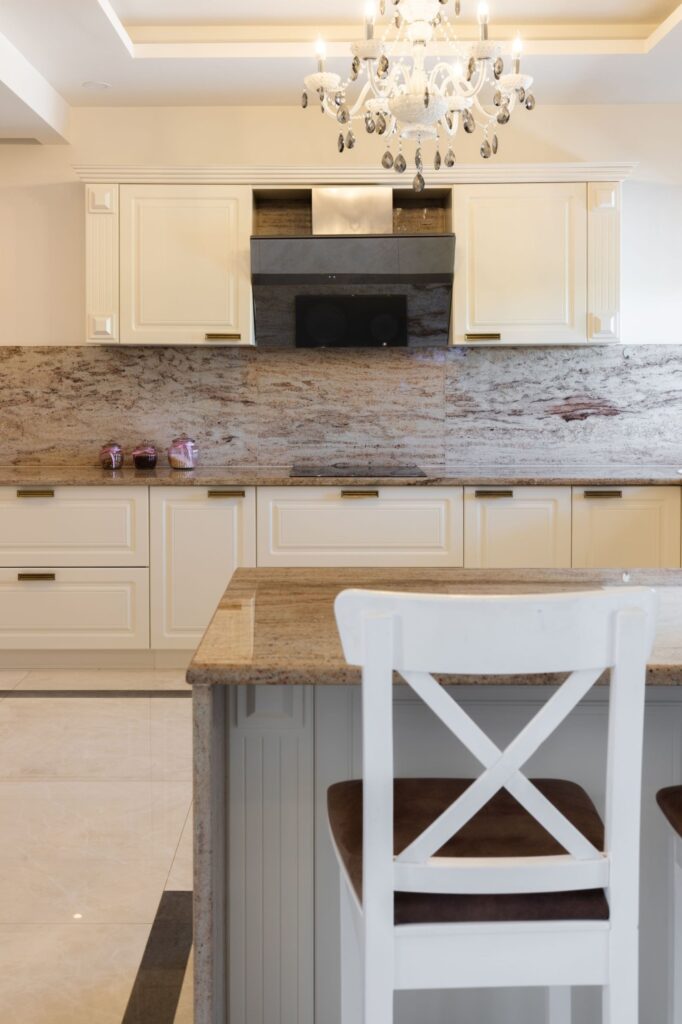 Elegante Küche nach Mass im klassischen Design mit Kronleuchter und Naturstein