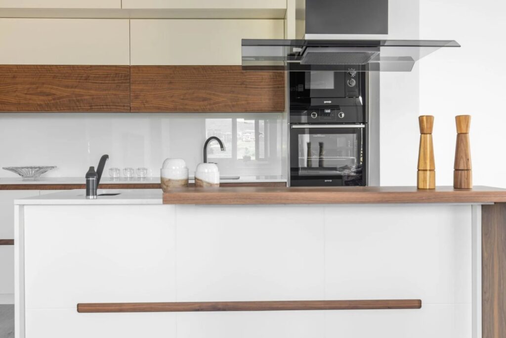 Moderne Küche nach Mass mit weisser Kochinsel und Holzdetails in der Schweiz