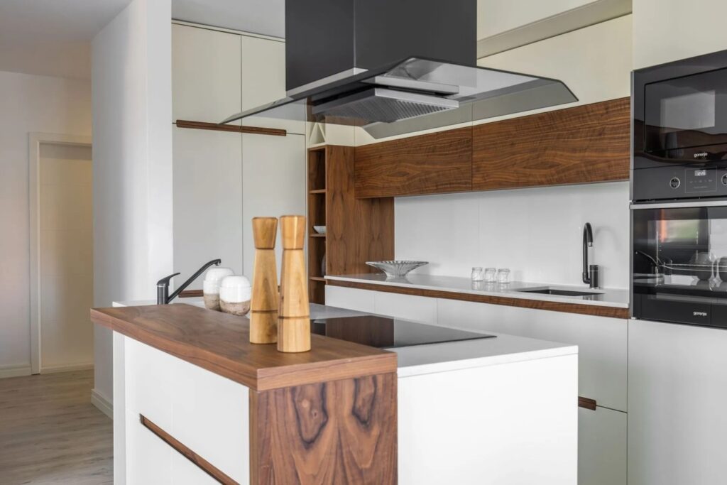 Kochinsel einer massgefertigten Küche mit integrierter Kochfläche und moderner Abzugshaube
