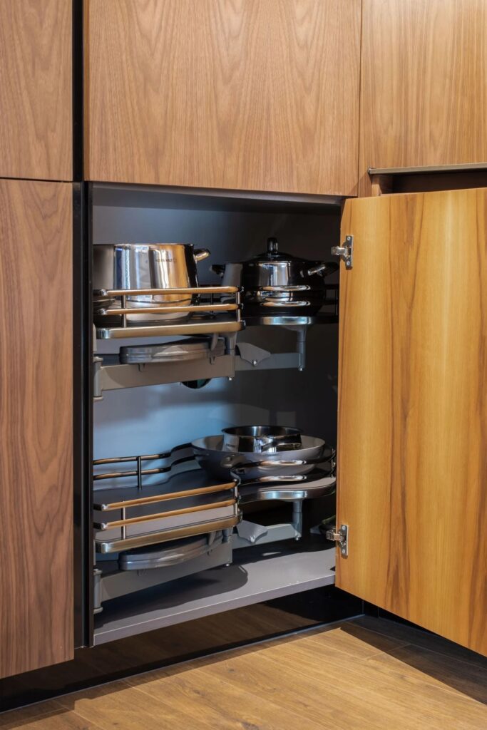 Intelligente Eckschrank Lösung mit ausziehbarem Stauraum in moderner Holzküche nach Mass