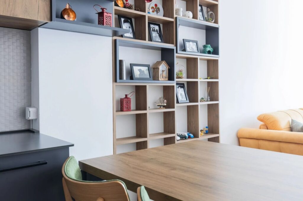 Moderne Küche nach Mass mit integriertem Holzregal und Essbereich in der Schweiz