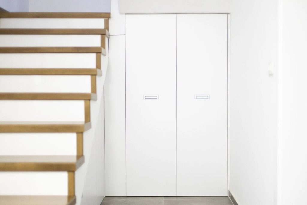 Weisser Einbauschrank nach Mass unter Treppe mit minimalistischem Design und klaren Linien