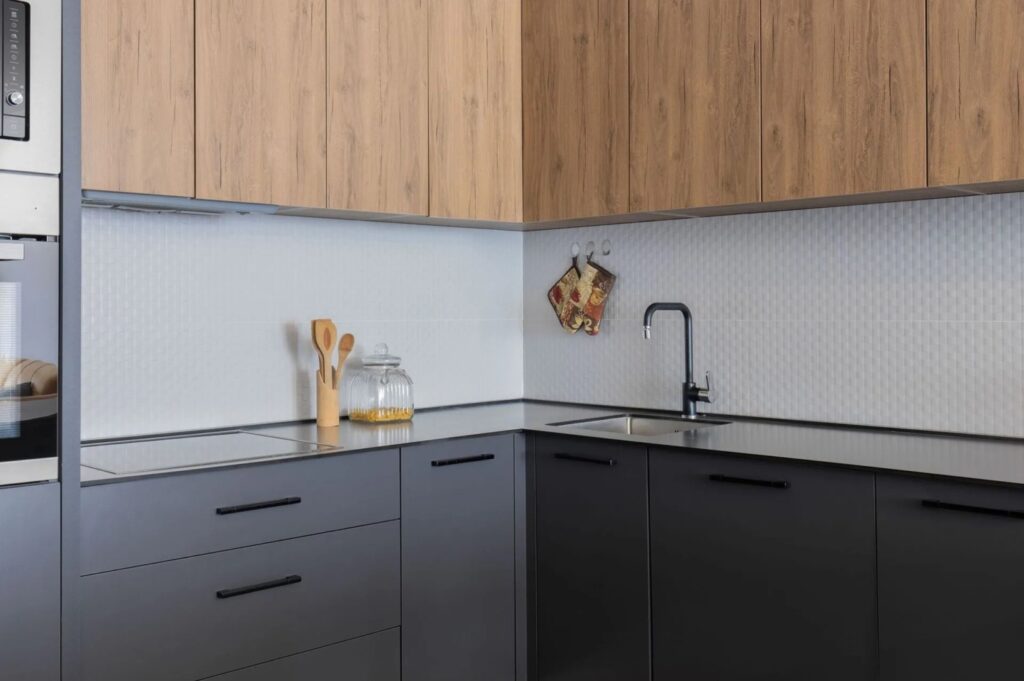 Eckküche nach Mass mit schwarzen Unterschränken und Holzoberschränken