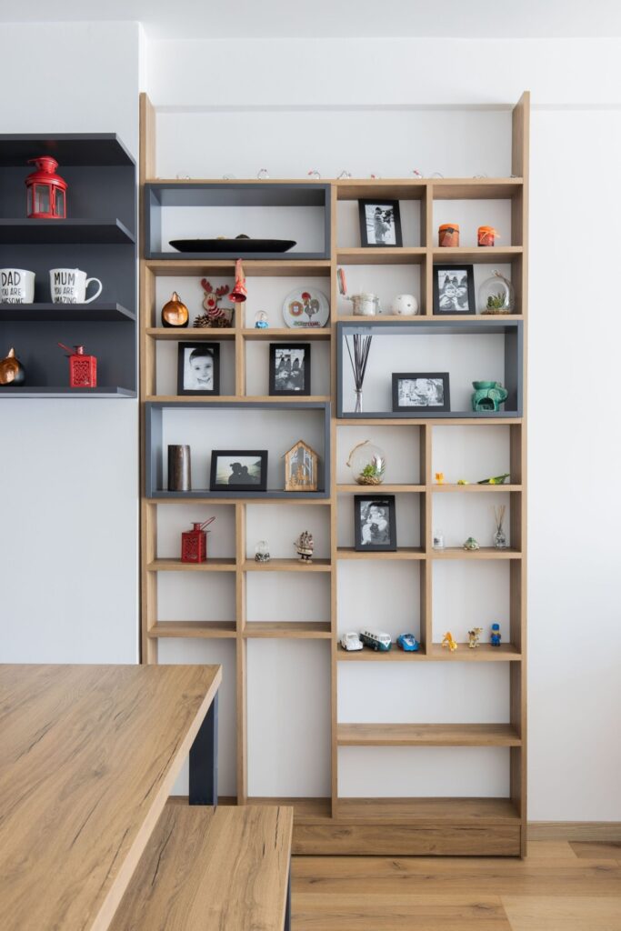 Hoher Einbauschrank nach Mass aus Holz mit offenen Regalen und Dekoration