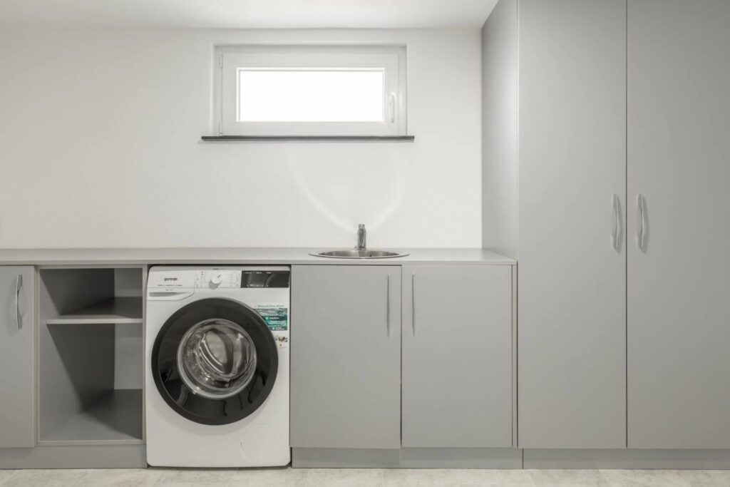 Einbauschrank nach Mass in Waschküche mit integriertem Waschmaschinenbereich und Stauraum