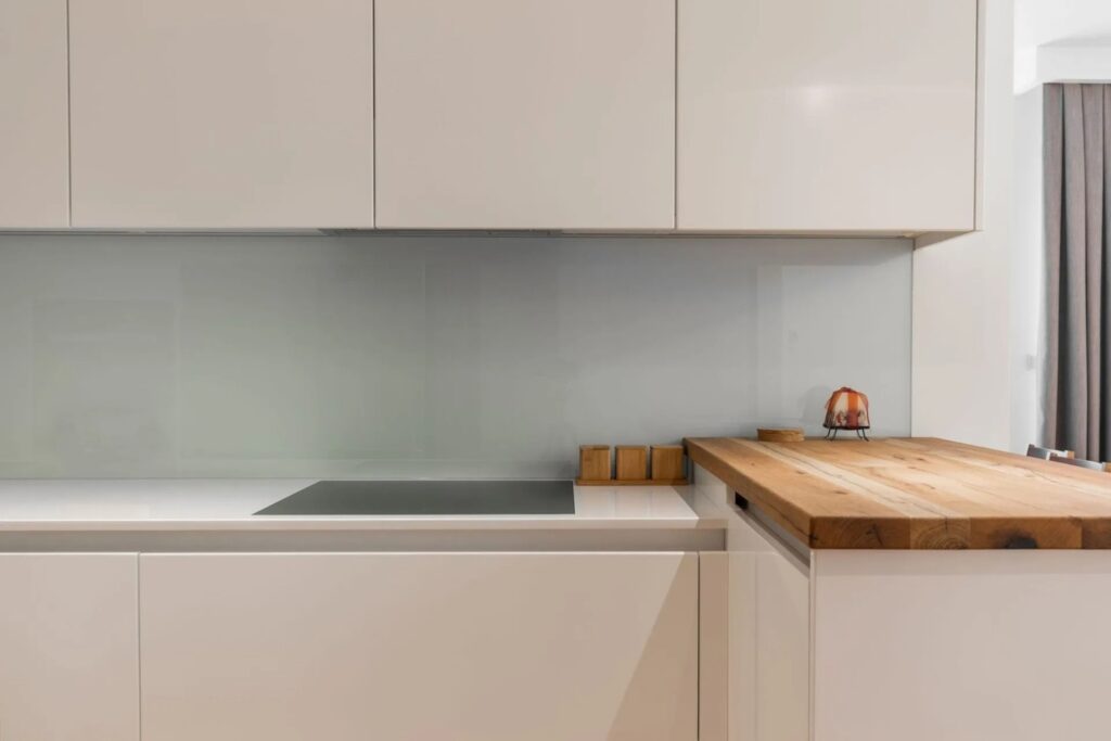 Minimalistische Küche nach Mass mit weissen Fronten und Holzarbeitsfläche – Schweiz